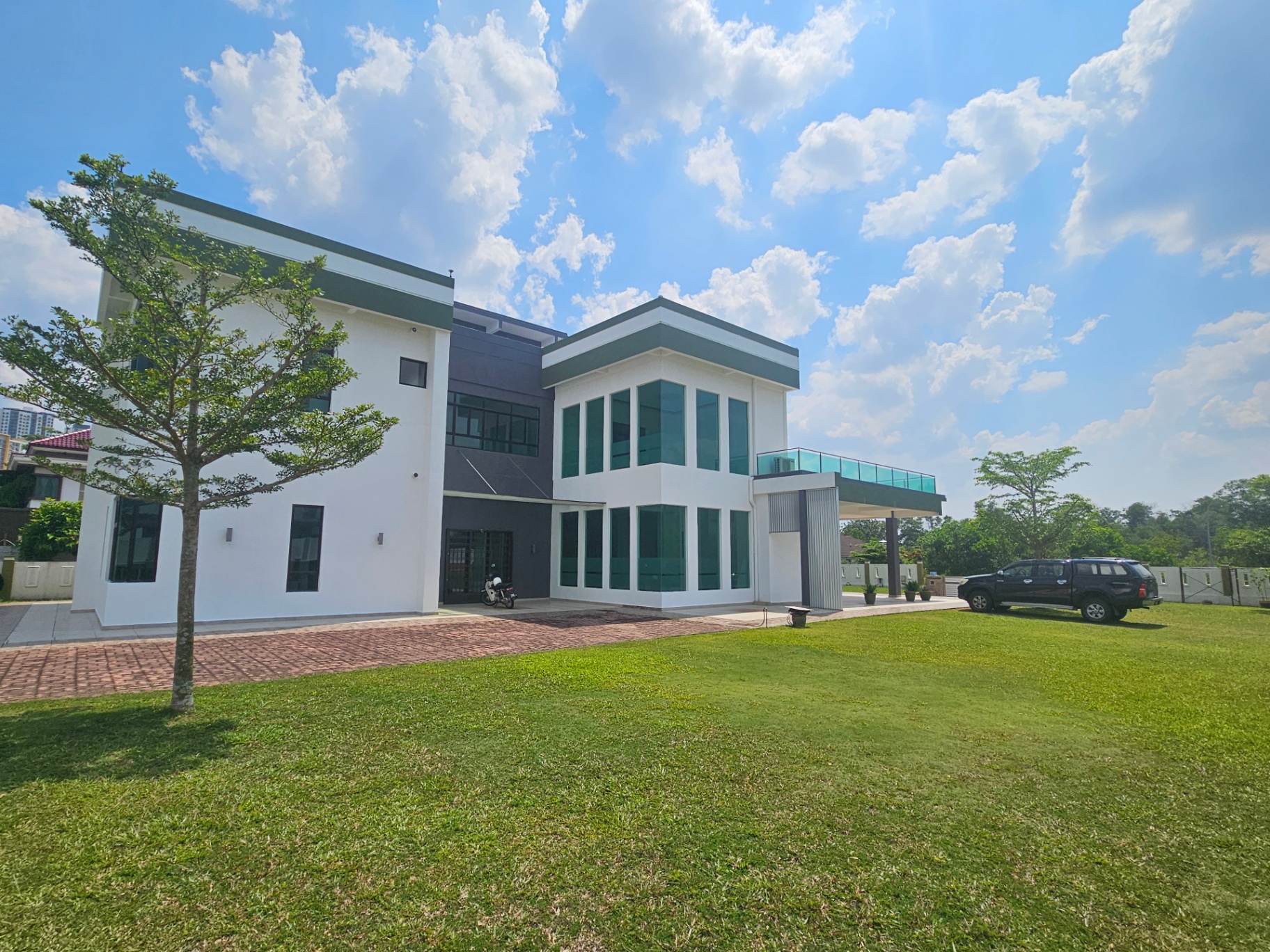 Modern villa with green trimmed roofline and floor-to-ceiling glazing